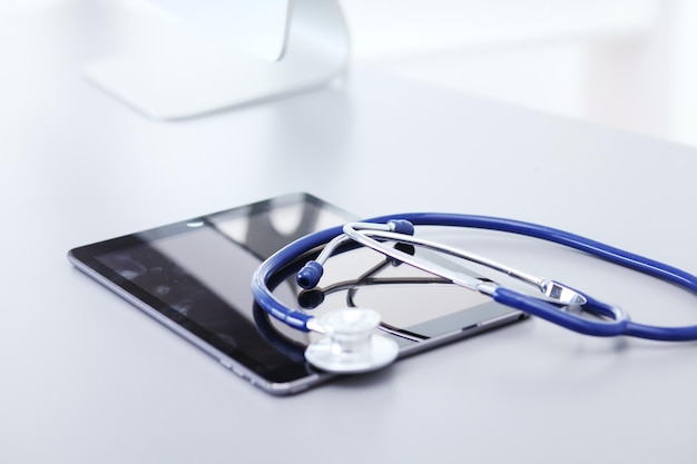 Medische apparatuur blauwe stethoscoop en tablet op witte achtergrond medische apparatuur