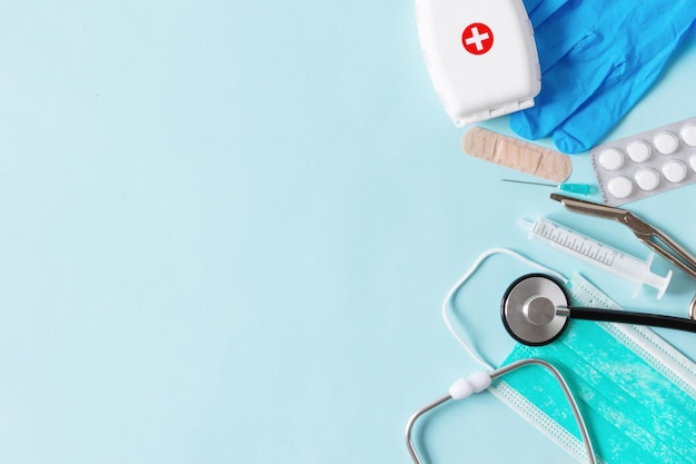 Medische apparatuur met stethoscoopschaarspuiten en andere objecten op blauwe achtergrond bovenaanzicht