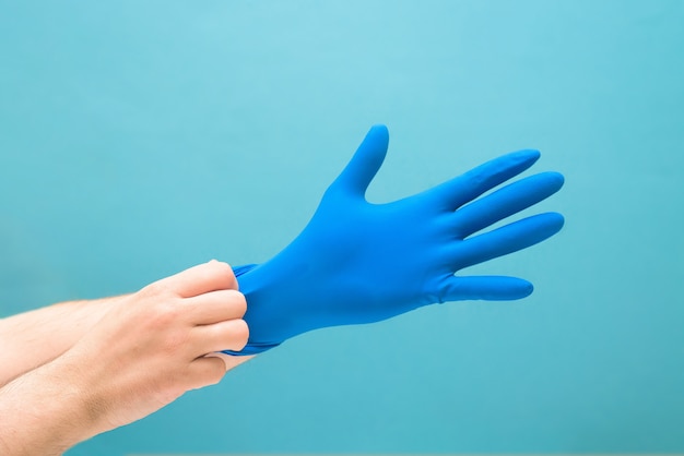 Medische blauwe handschoen aan de man de hand van coronavirus. het lichaam beschermen tegen virussen en bacteriën