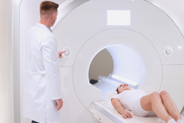 Medische computertomografie of mri-scanner mannelijke radioloog drukt op de mri-knop om te onderzoeken