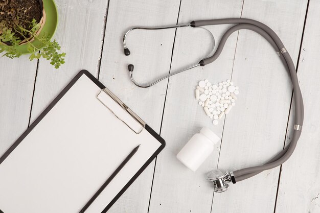 Foto medische concept stethoscoop pad fles en wit hart van pillen en capsules