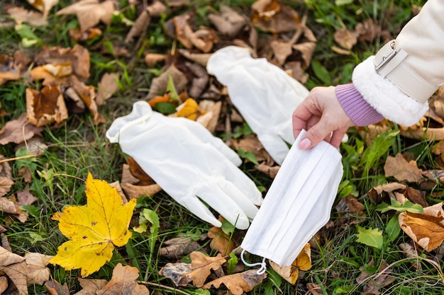 medische handschoenen en een masker liggen op de grond in een herfstpark