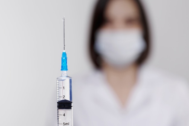 Medische injectie, ziekten, gezondheidszorg, wetenschap, diabetes. Arts of verpleegkundige in het ziekenhuis met een spuit met vloeibare vaccins voorbereiden om een injectie te doen. Medische apparatuur. Mensen in wit uniform, kleed