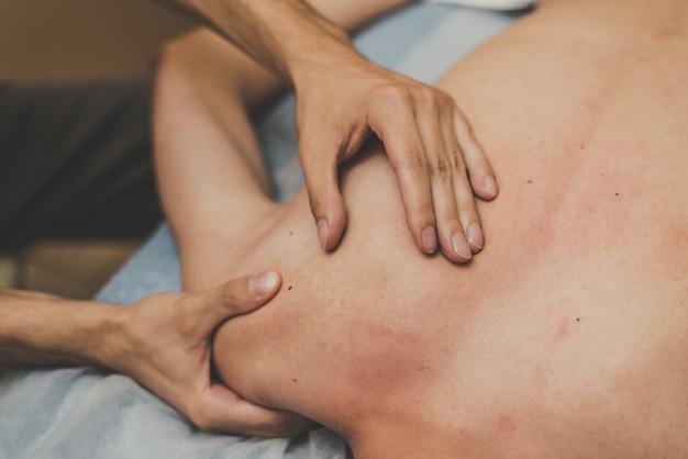 Medische massage van de wervelkolom. Masseur masseert een tiener in een kliniek