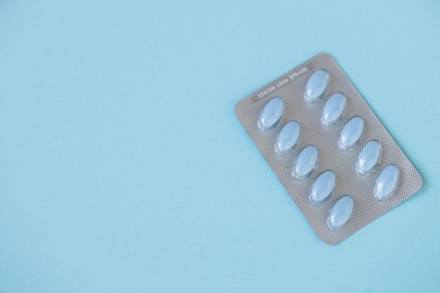 Medische pillen op blauwe achtergrond bovenaanzicht kopie ruimte