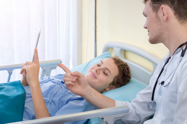 Medische professionals Kaukasische man opname en het nemen van informatie naar tablet op bed.