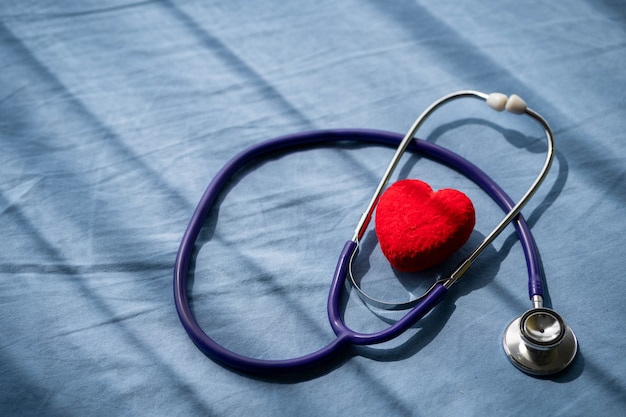 Medische stethoscoop en rood hart op het bed van de patiënt. Concept gezondheidszorg.