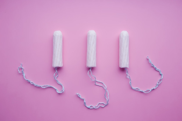 Medische vrouwelijke tampons op een roze achtergrond. Witte tampon voor vrouwen.