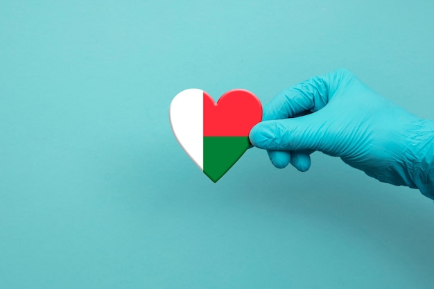 Medische werkers die een chirurgische handschoen dragen met het hart van de vlag van Madagaskar