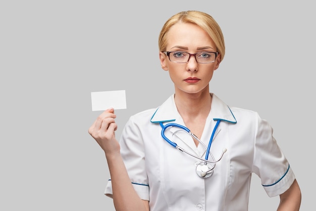 Medische werkersarts of verpleegster die leeg visitekaartje tonen