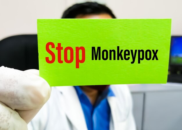 Medische wetenschapper houdt een kaart vast met de tekst Stop Monkeypox voor het gebruik van gezondheids- en medische concepten