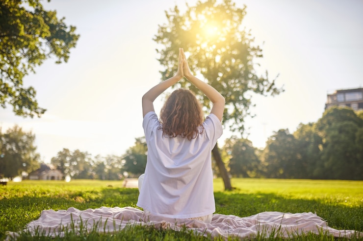 Foto meditatie. een meisje dat in een lotushouding zit en mediteert in het park
