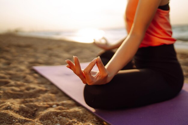 Meditatie Jonge vrouw doet yoga bij de oceaan blootsvoets Kalmte en evenwicht gezonde levensstijl