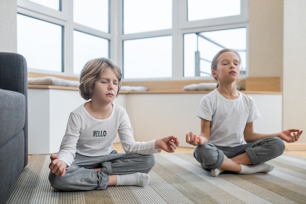 Meditatie. kinderen die thuis samen yoga doen en in meditatie zitten