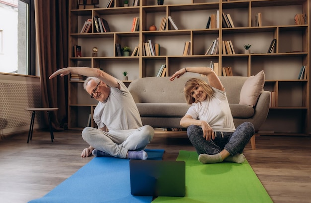 Meditatie senior koppel en tutorial oefening voor training, training en gezondheid voor wellness en ontspanning thuis Pensioen man en vrouw streamen met laptop om yoga, fitness en stretching te doen