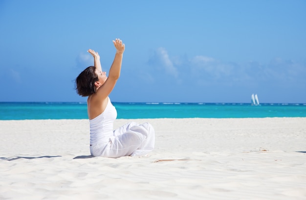 meditatie van gelukkige vrouw in lotus houding op het strand