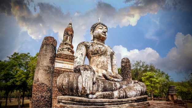 寺院と美しい空を背景に仏を瞑想します。タイのユネスコ世界遺産であるスコータイ歴史公園のワット・トラパン・ゴエン