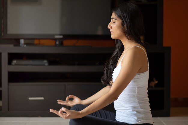 Meditating at home mexican woman