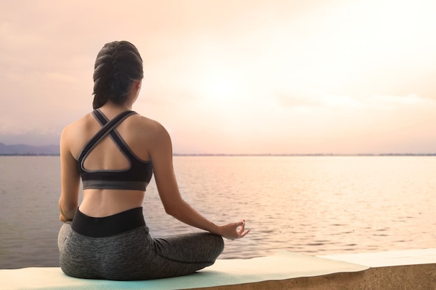 Meditating Woman practices yoga relax in nature 