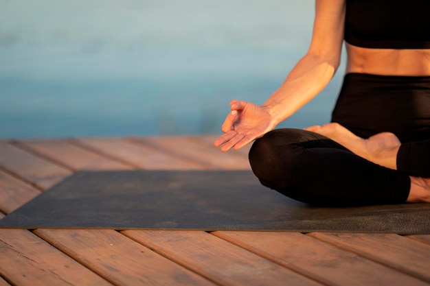 Concetto di meditazione ritagliata colpo di donna in abbigliamento sportivo che medita all'aperto