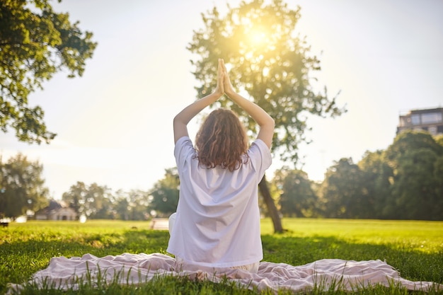 Meditation. a girl sitting on a lotus pose and meditating in the park