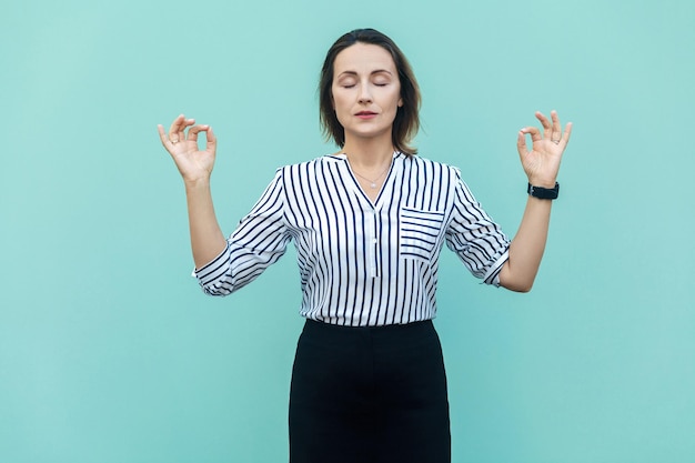 Meditation religion and spiritual practises beautiful business woman doing yoga indoors at light