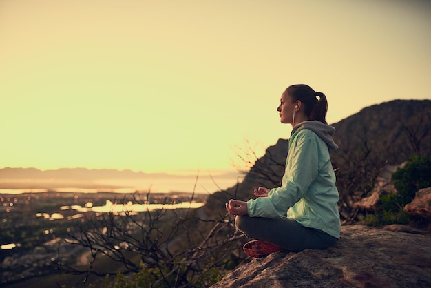 Meditation with a view Full length shot of a sporty young woman meditating outdoors