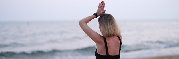 Foto mediterende yogavrouw zit op het strand aan zee