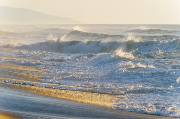 Mediterrane kust met golven bij zonsondergang