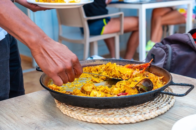 Mediterrane paella zeevruchten rijstmaaltijd aan de kust van Ibiza ober serveren