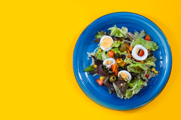 Mediterrane salade die van bovenaf op geel wordt gezien