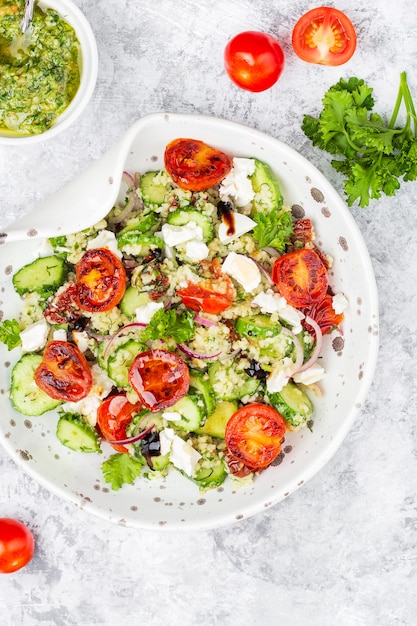 Mediterranean couscous salad with fried cherry tomatoes, cucumber and pesto sauce