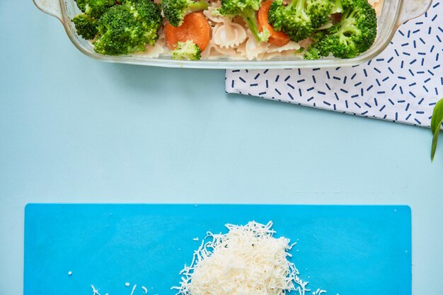 Mediterranean cuisine Italian dish pasta with vegetables Grated cheese on a board Top view High quality photo