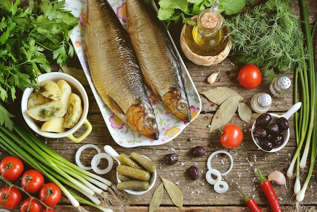 Cucina mediterranea: aringa affumicata con patate lesse, olive secche, cipolle verdi e cetrioli sottaceto. stile rustico.