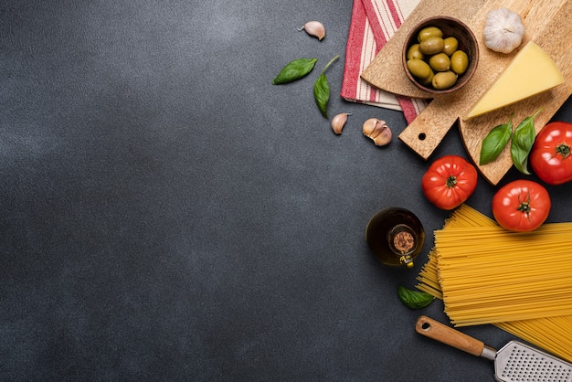 mediterranean food background with red tomatoes spaghetti olives basil olive oil garlic