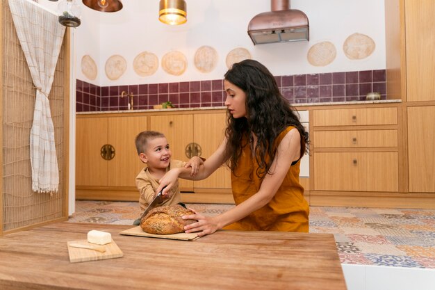 Foto medium geschoten vrouw en kind in de keuken