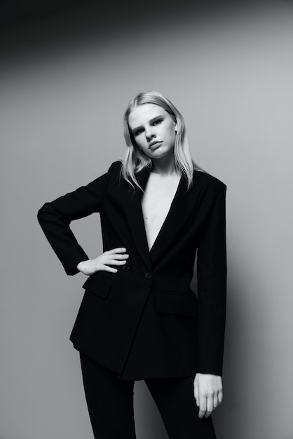 Medium portret van een elegant meisje in een formeel pak en zwart jasje in de studio Zwart-witstijl Concept voor kledingmerken