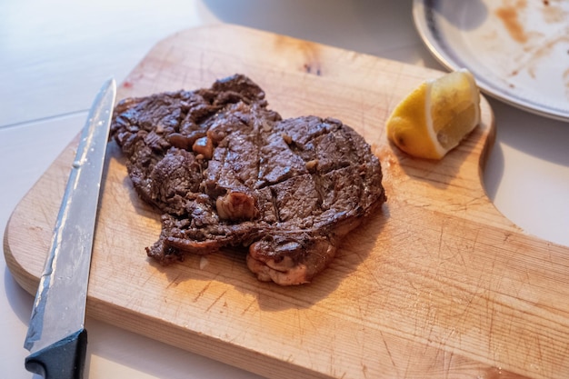 Foto manzo al sangue alla griglia con fetta di limone su tagliere di legno