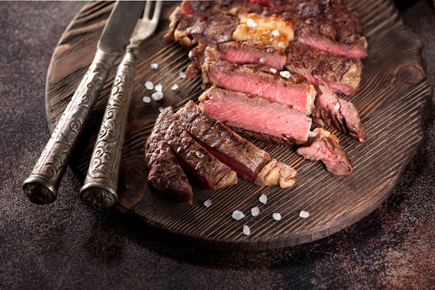 Medium rare gegrilde biefstuk ribeye op een houten serveerplank