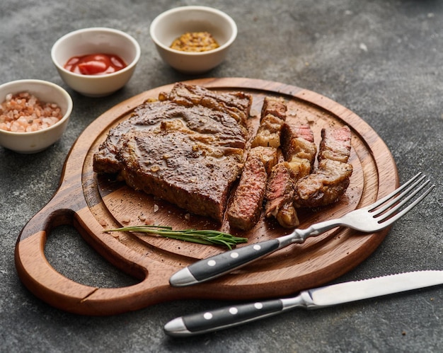 Medium rare Ribeye steak of beefsteak op het houten dienblad met kruiden