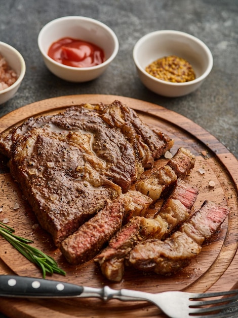 Medium rare Ribeye steak of beefsteak op het houten dienblad met kruiden