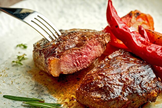 Medium rare steak on a white plate with spices Closeup selective focus