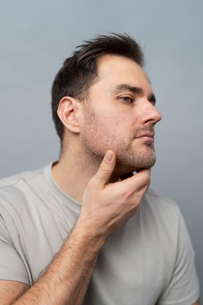 medium shot adult touching his face