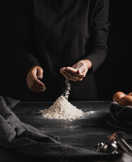 Medium shot baker hands mixing flour