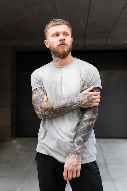 Medium shot blonde man with tattoos