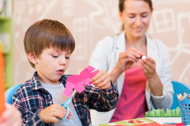 Photo medium shot blurred teacher helping boy