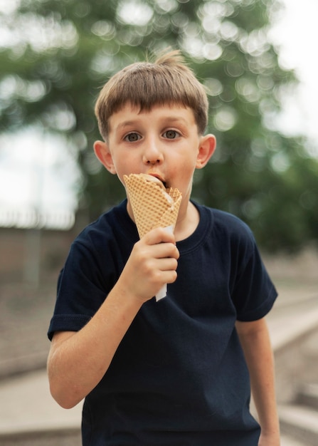 Foto ragazzo del colpo medio che mangia il gelato