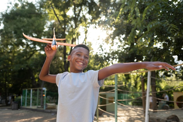 Foto ragazzo con colpo medio che tiene aereo