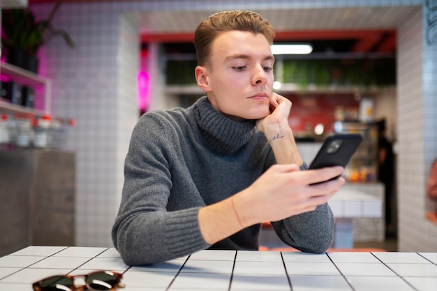 Photo medium shot boy holding smartphone