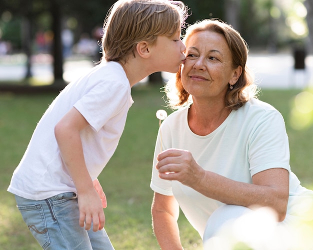 写真 おばあちゃんにキスするミディアムショットの少年